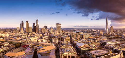 Wall Mural - Panoramic skyline of the famous business district of London at sunset with dark clouds - London, UK