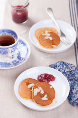 Wall Mural - Pumpkin pancakes with honey, nuts and jam in a white plate on a table.