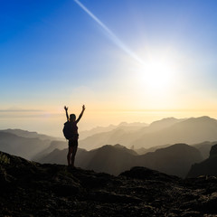 Wall Mural - woman hiking success silhouette in mountains sunset
