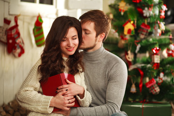 Happy couple in house on background of Christmas decorations