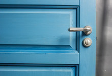 Open Wooden Door Painted In Blue With A Beautiful A Metal Handle And The Castle