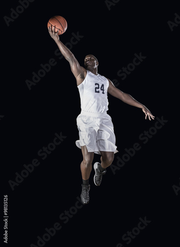 Basketball Player jumping high and scoring a layup basket