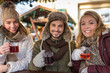 Couple and friend, Friends on a german  Christmas market enjoying traditional mullet wine and talk to each other