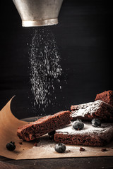 Wall Mural - Sprinkling chocolate brownie with icing sugar horizontal