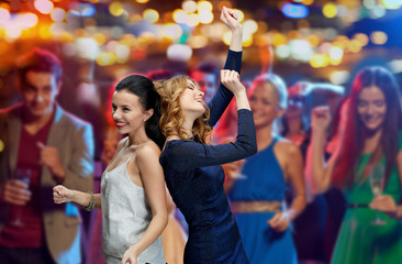 happy young women dancing at night club disco