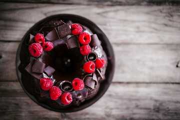 Canvas Print - Chocolate cake with raspberries on rustic wooden background