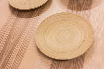 The brown wooden plate on a rustic table closeup.