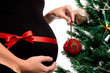 Closeup  of  Pregnant woman with red satin ribbon