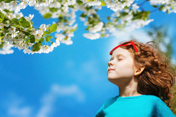 Wall Mural - Little girl closed her eyes and breathes the fresh air in the pa