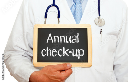 Fotografía Annual check-up - doctor holding chalkboard with text on white background