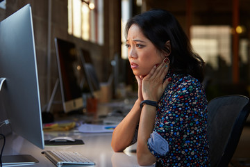 Stressed Female Designer Works At Computer In Modern Office