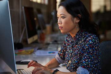 Female Designer Working At Desk In Modern Office