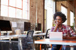 © Monkey Business - Designer Sits At Meeting Table Working On Digital Tablet