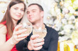 beautiful happy couple celebrating New Year, holding glasses of champagne