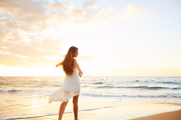 Wall Mural - Happy Carefree Woman on the Beach at Sunset