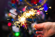 © volhavasilevich - Soft and blur conception.Female hand holding a burning sparklers closeup. New Year's and Christmas