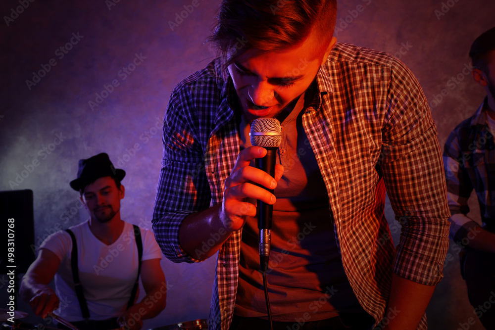 Musicians playing musical instruments and singing songs in a studio