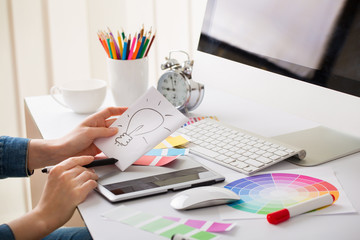 Young designer woman with beautiful hands with idea sign and tab