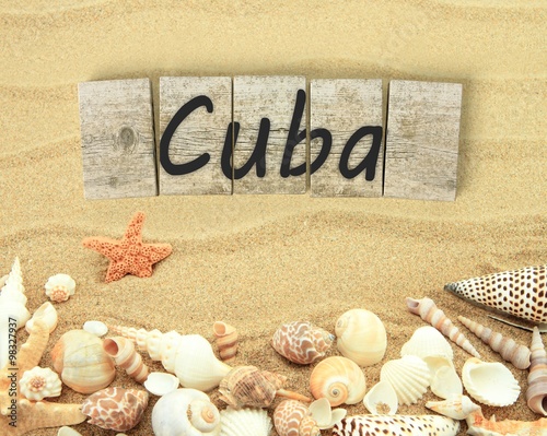 Fototapeta na wymiar Cuba on wooden board pieces with sea shells and sand