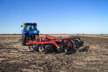 Poster - Powerful tractor plowing a field
