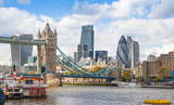 Fototapeta Mosty linowy / wiszący - LONDON, UK - APRIL 30, 2015: Tower bridge and City of London financial aria on the background. View includes Gherkin and other buildings