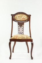 Front View Antique Art Nouvea Mahogany Parlour Chair With Typical Flowing Curving Lines And Fruit And Floral Carved Detail With Original Upholstery On A White Background