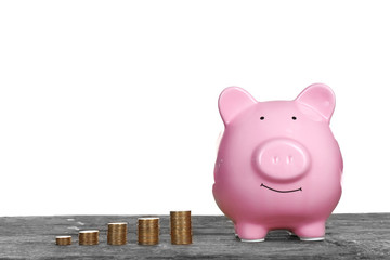 Poster - Piggy bank with coins on wooden table, isolated on white