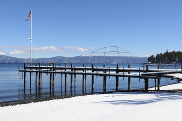 Wall Mural - Travel: Lake Tahoe - beach with snow and flag