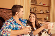 © deagreez - Cute young couple siting together with cups and smiling