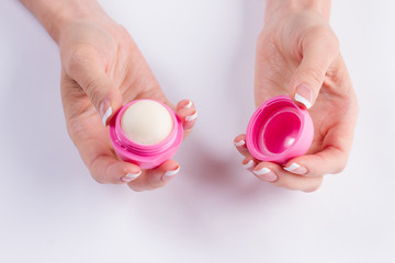 Fotomurales - Pink lip balm in a beautiful female fingers.
