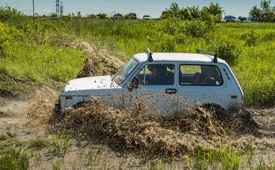 Off-road vehicle brand VAZ-NIVA overcomes a pit of mud