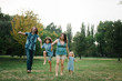 © sergiubirca - Happy young hipster family having fun while running, bowl,  rising up, piggyback ride their children in park on summer sunset