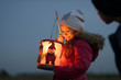 © Westend61 - Smiling little girl with self-made paper lantern in the evening