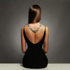Wall Mural - beautiful back of young woman in sexy dress.luxury.sitting girl with necklace