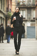 © Westend61 - Spain, Catalunya, Barcelona, young black dressed businesswoman with coffee to go in front of a street