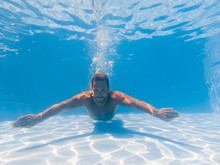 Man Swimming Underwater In The Swimming Poll