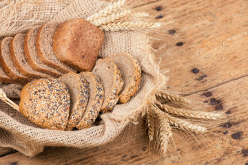 Rustic bread and wheat on an old vintage planked wooden table