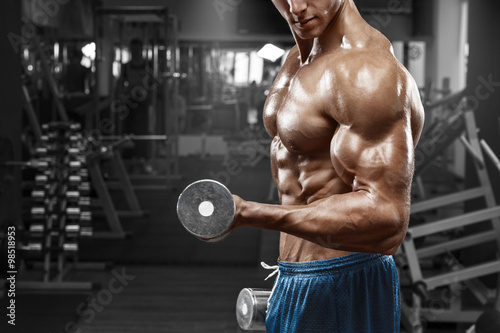 Muscular man travaillant dans le gymnase faire des exercices avec des haltères a Tableau sur Toile