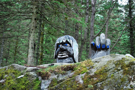 Troll Figure / wooden troll statue behind the rock in Bergen park, Norway