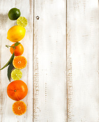 Sticker - Fresh citrus fruits with leaves on wooden background