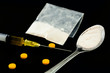 Drug syringe, amphetamine tablets.