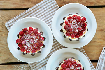 Sticker - Sweet cakes with raspberries on light wooden background