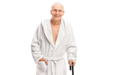 Wall Mural - Senior man in a bathrobe holding a cane