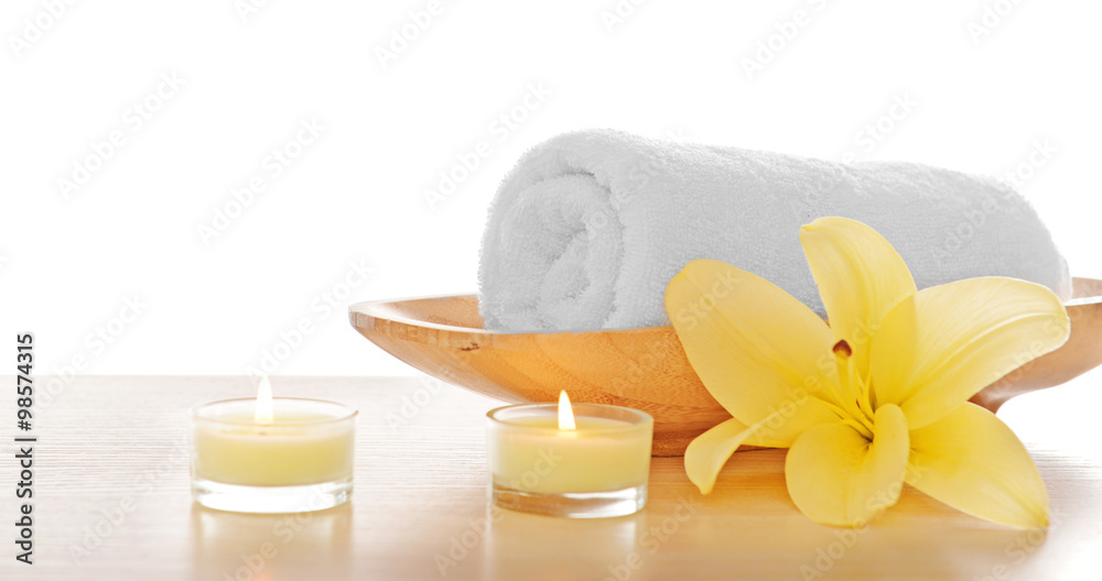 Spa towel with candles and lily, isolated on white