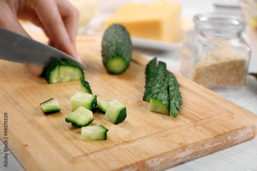 Female hands cutting vegetables for salad, at kitchen