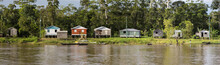 Wooden House On Stilts Along The Amazon River And Rain Forest, B