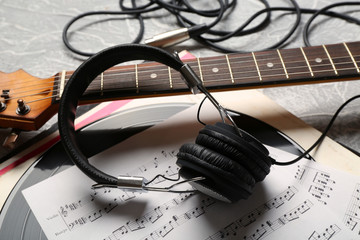 Electric guitar and headphones with music notes on grey background