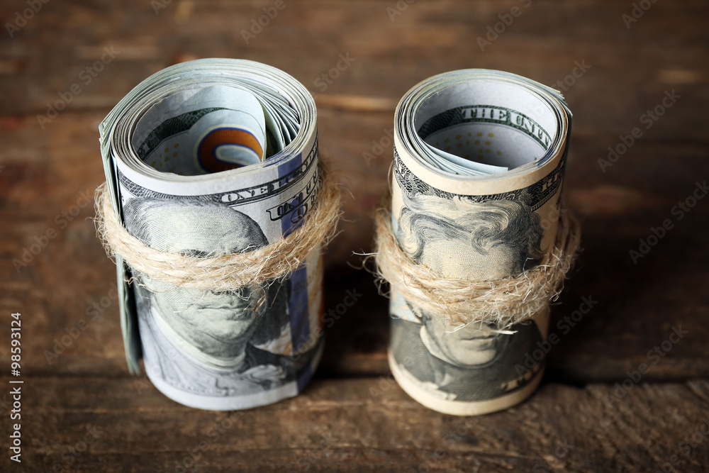 Dollars roll on wooden background