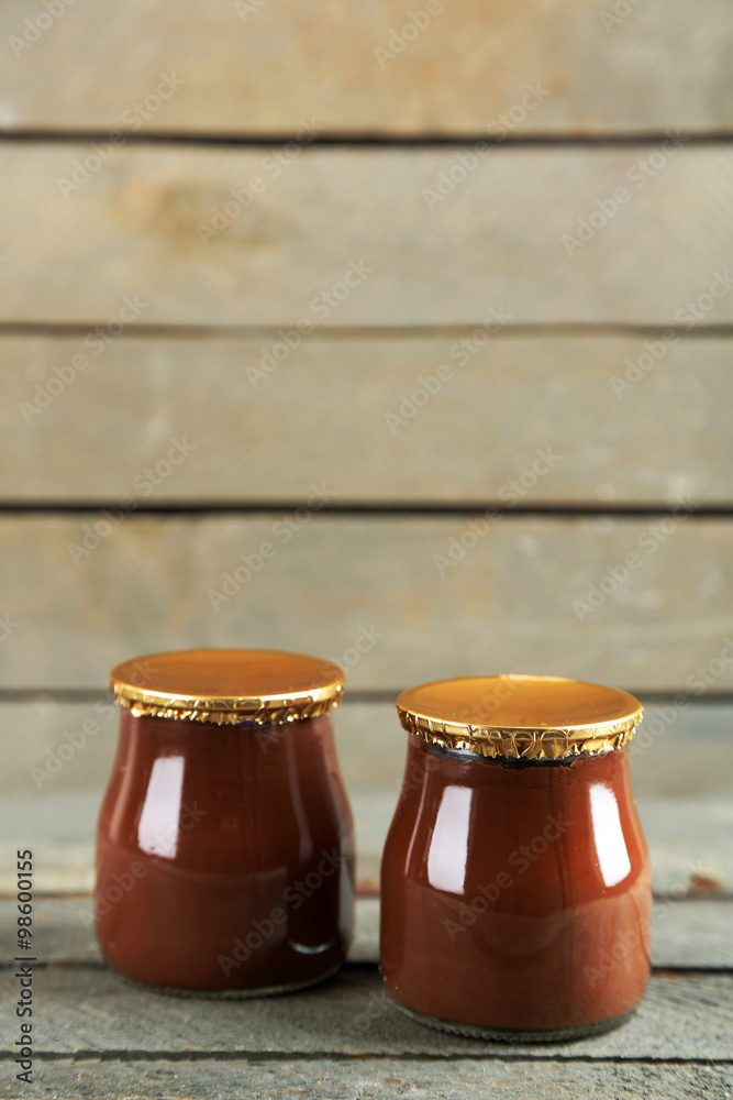 Chocolate dessert in a small glass jars on wooden background