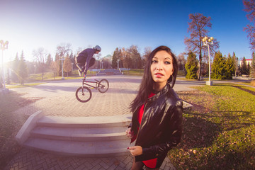 Woman and BMX cyclist doing a stunt jump